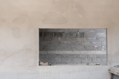 window on cement wall with brick wall background in construction buildingの写真素材