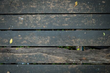 old wooden walkway with falling leaves in the morning of autumn seasonal