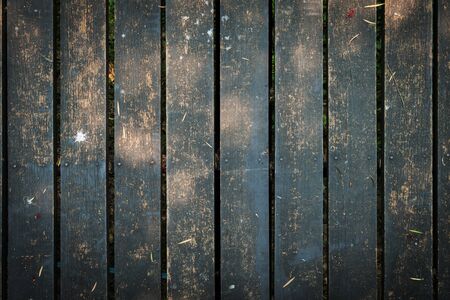 old wooden walkway with falling leaves in the morning of autumn seasonal