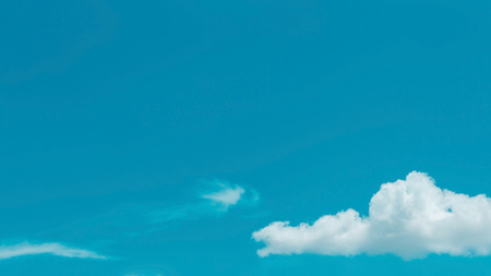 fluffy single cloud on clear blue sky background