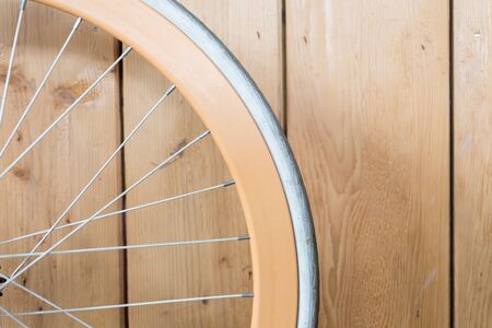 orange bicycle parked with wood wall, close up image part of bicycleの写真素材
