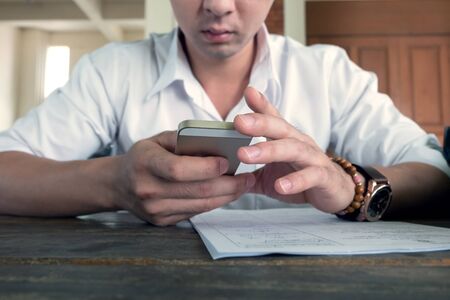 businessman using a mobile phone with texting message on app smartphone, playing internet on mobileの写真素材