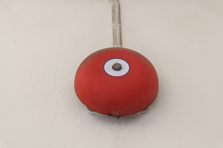 red fire alarm bell for warning security system mounted on wallの写真素材