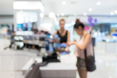 woman buy sets of makeup in department store shopping mall, image blur defocused backgroundの写真素材