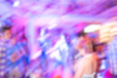 image blurred background, group of young people having joyful dancing in nightclub partyの写真素材