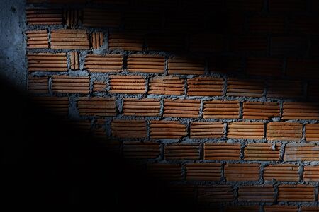 brick wall in residential construction site with light sunshine through the window