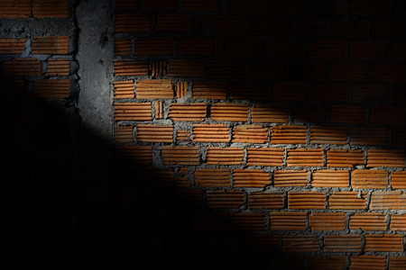 brick wall in residential construction site with light sunshine through the window