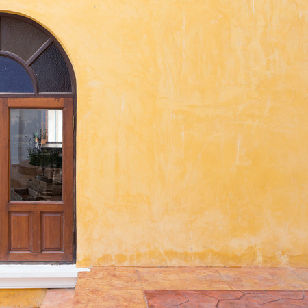wood window on yellow cement mortar wall backgroundの写真素材