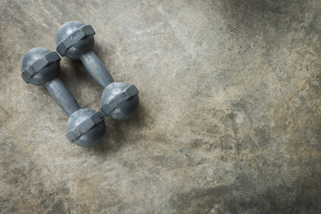 metal dumbbell on cement floor, fitness sport of bodybuilding backgroundの写真素材