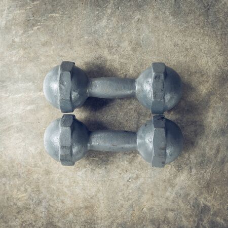 metal dumbbell on cement floor, fitness sport of bodybuilding backgroundの写真素材
