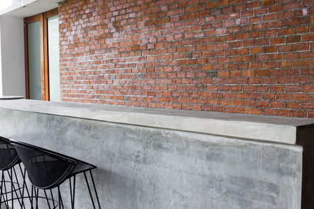 design of interior, counter bar made from cement with iron seat bar stool and brick wall backgroundの写真素材