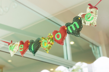 welcome message heart alphabet handmade hanging on mirror of decoration cafe coffee shop vintage styleの写真素材