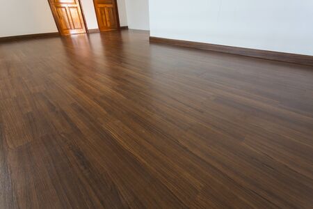 empty room, white mortar wall background and wood laminate floor in residentialの写真素材