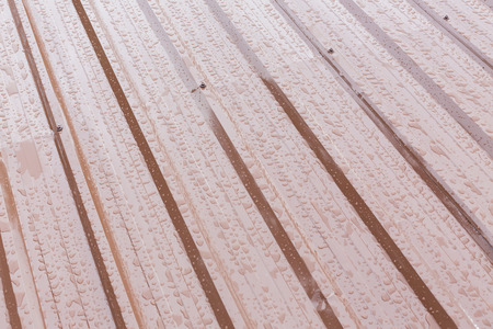 rain drops water on brown roof metal sheetの写真素材