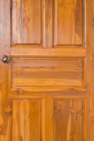 brown wood door with door knob and keyhole in residential houseの写真素材