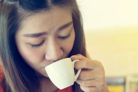 female drinking hot coffee in cafe, beautiful asian women modelの写真素材