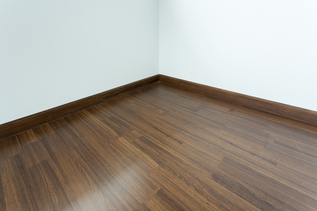 empty room interior, brown wood laminate floor and white mortar wallの写真素材