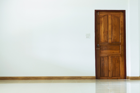 empty room interior with wooden door and white mortar wallの写真素材