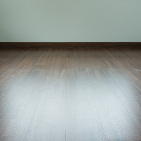 empty room interior, brown wood laminate floor and white mortar wallの写真素材
