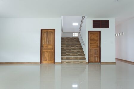 white empty room interior with wooden door and staircaseの写真素材