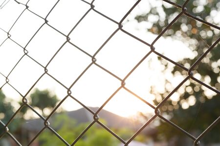 steel wire mesh fence with sunlight backgroundの写真素材