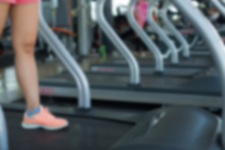 blurred human walking exercise on run treadmill machine cardio equipment at sport healthy club center, image for banner advertising backgroundの写真素材