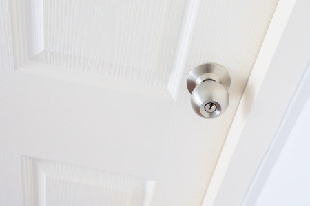 white wood pane door closed and silver knob lock in industrial building houseの写真素材