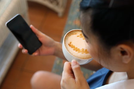 freelance business woman drinking hot coffee and using internet mobile phone technology working...