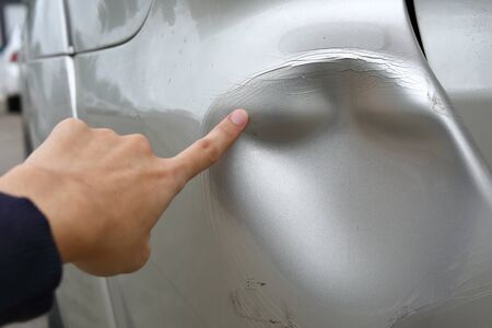 sufferer hand point of vehicle car bumper dented broken from collision crash damage accident on roadの写真素材