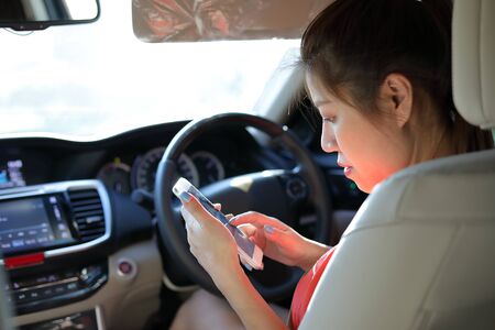 asian business woman using mobile phone communication working in vehicle car