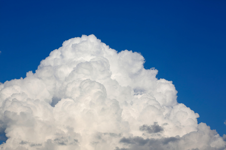 fluffy white cloud above clear blue sky backgroundの写真素材