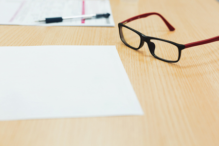 paper and eyeglasses on office tableの写真素材