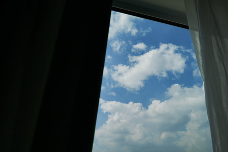 glass window with cloud above blue sky outside the roomの写真素材