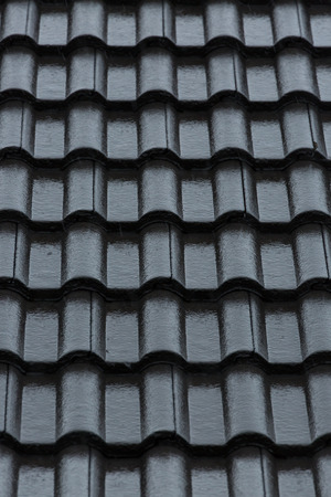 rain storm downpour on black roof tile of residential houseの写真素材