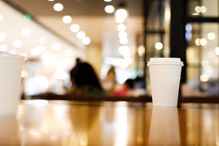 take away coffee cup empty blank copy space for your design text or banner of brand, hot drink on wood table in cafe shop restaurant with light decor celebration party, image used retro vintage filterの写真素材