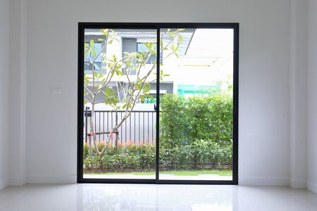 slide glass door with small garden landscaping in front of a new house