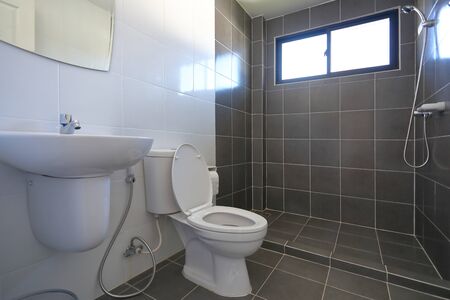 modern design of small bathroom with white lavatory water closet and used black tile wall and floorの写真素材