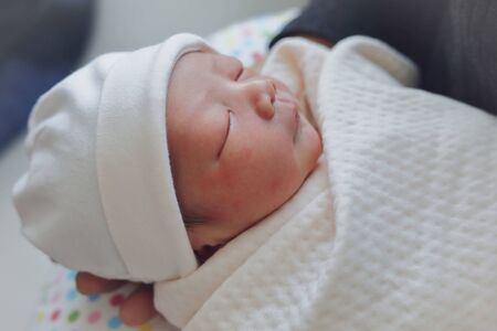 innocence face of cute baby newborn close eye sleeping in white blanket childhoodの写真素材