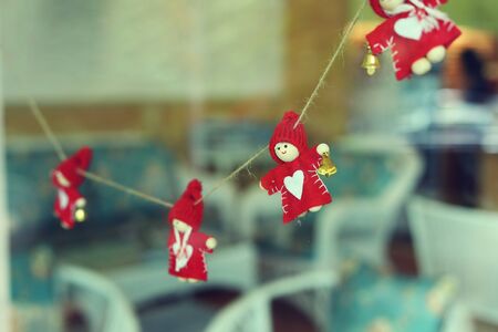 little christmas doll hanging decoration on glass windowの写真素材