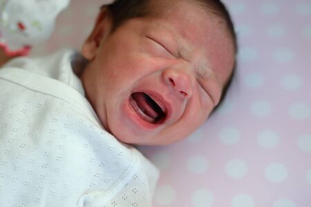 cute newborn baby cry on bedの写真素材