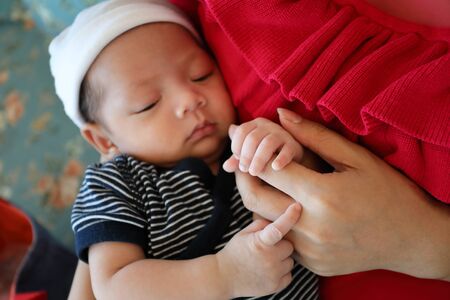 mother holding hand of baby with loveの写真素材