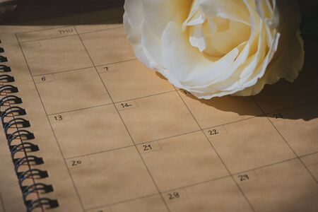empty message in schedule book of calendar with white rose flower put on table workの写真素材
