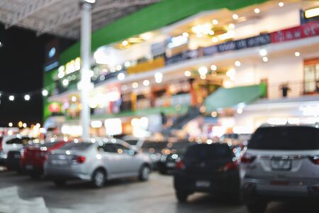 blur night light in business building with car park, abstract blurry bokeh of city backgroundの写真素材