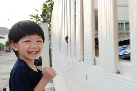 cute boy and dog cute pet playing in front gateの写真素材