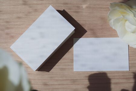 empty business card with white paper blank for design text message of contact your name and job description put on wooden office tableの写真素材