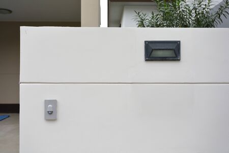 doorbell on white wall of front gate