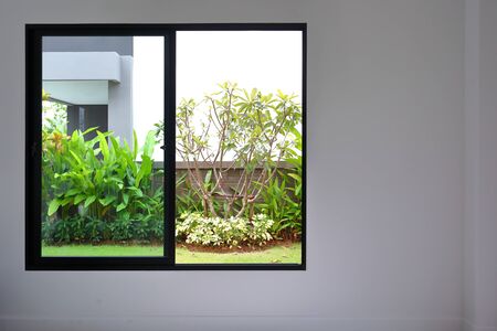 slide glass window on white wall interior in modern empty room with small garden landscaping outside a new houseの写真素材