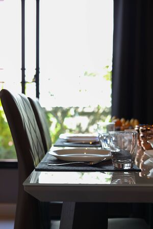 dish ware sets arrange on breakfast table inside eating room of modern home interiorの写真素材