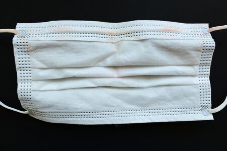 dirty used medical hygiene face mask on black background