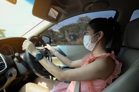 woman wearing medical mask drive car